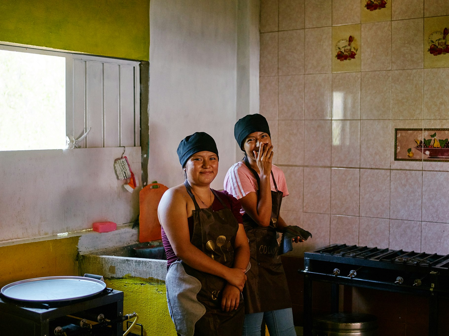 Two women standing in their restaurant kitchen.