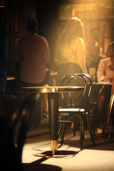 Two people in the distance of a busy bar behind text 'Gold's role in a Portfolio, and Society'