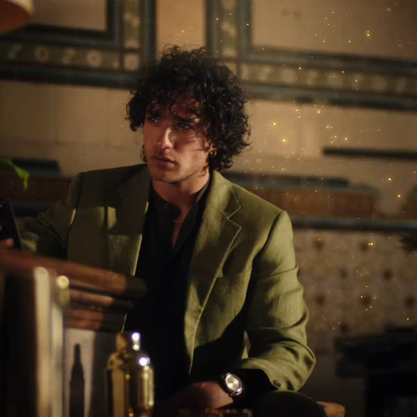 A shot of a person in a green jacket behind a bar
